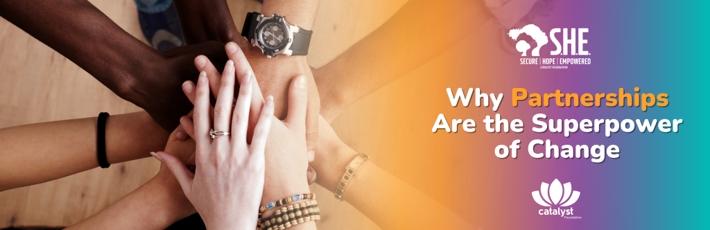 A close-up, top-down photograph showing a diverse group of people stacking their hands together in the center of the frame, symbolizing unity and partnership. The background is a mix of warm orange and cool turquoise colors with white text overlaid. The text reads: "Why Partnerships Are the Superpower of Change". The image also features the logos for "SHE: Secure Hope Empowered" and the "Catalyst Foundation".