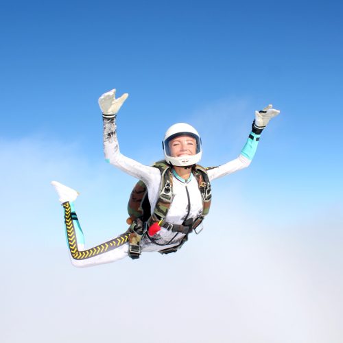 Skydiving.,An,Young,Woman,Is,Flying,In,The,Sky.